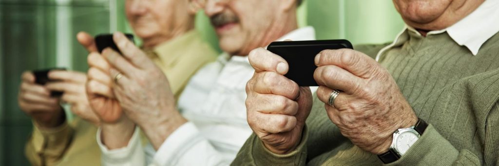 пожилые люди смотрят в смартфоны