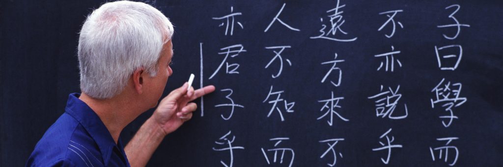 Человек рисует на доске Китайские иероглифы