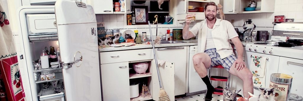 мужчина на кухне в окружении котят