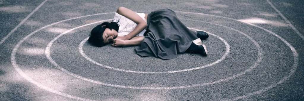 Девушка лежит на асфальте в круге из мела