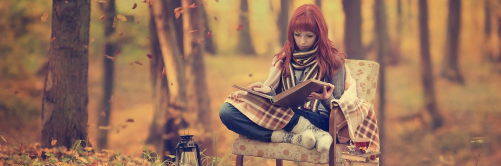 Девушка читает книгу в лесу