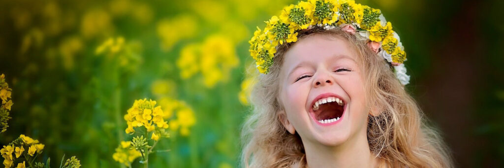 девочка в венке смеется на поле с цветами, счастье
