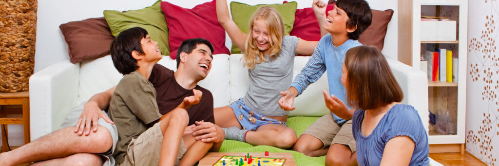 семья с детьми игреает в настольную игру