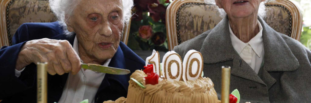 бабушка долгожительница режет торт со свечками
