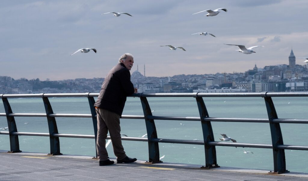 Пожлой мужчина смотрит вдаль